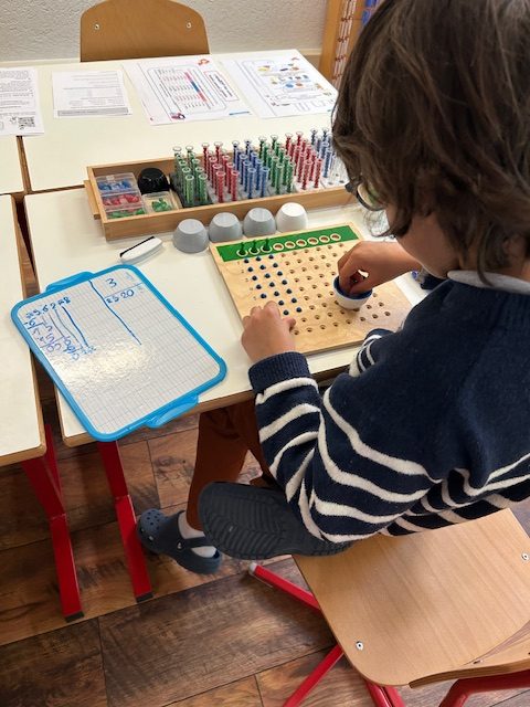 Un enfant manipule du matériel de calcul Montessori
