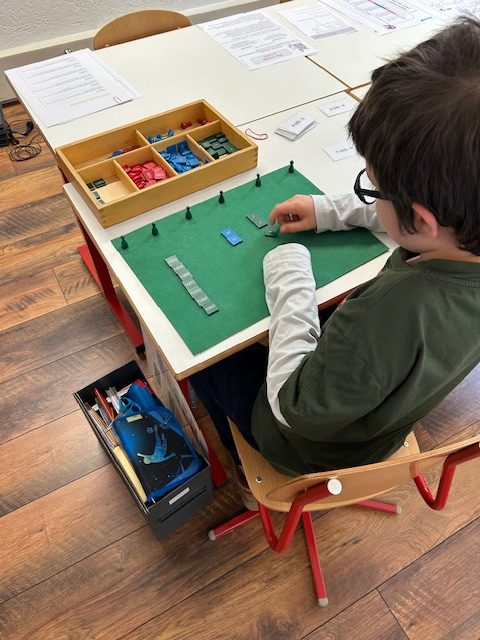Un enfant travaille avec le jeu de timbres Montessori